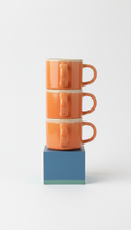 Stackable ceramic mug set with apricot accent